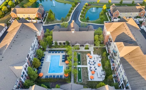 Aerial photograph of a residential complex with a large pool, mini-golf, outdoor seating, and two ponds with fountains.